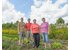 Auf dem Foto sind vier Bauern und Bäuerinnen auf einem Feld zu sehen.
