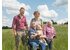 Foto von Familie Zach stehend und sitzend mit Hund in einem Feld.