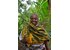 Photo of a woman who is holding a cardamom plant in her hand.