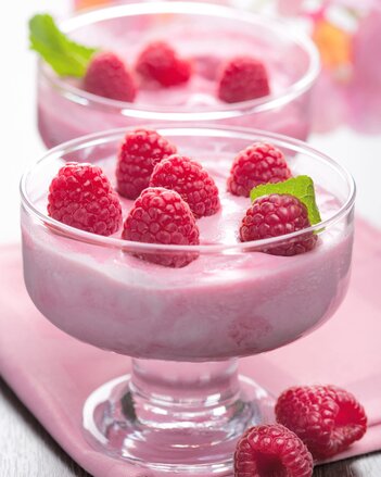 Auf dem Foto sieht man ein Dessertglas mit rosa Topfencreme. Darauf sind frische Himbeeren zu sehen. | © SONNENTOR