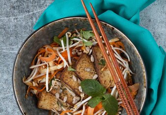 Auf dem Foto sieht man eine Schüssel mit Tofu Salat und Sprossen. Darauf sieht man zwei Stäbchen. | © SONNENTOR