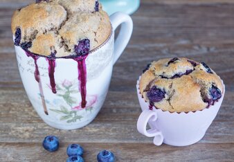 Auf dem Foto sind drei Tassen mit Heidelbeer-Anis-Tassenkuchen zu sehen. Davor sieht man auch frische Heidelbeeren. | © SONNENTOR