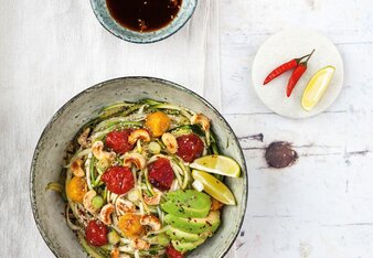 Auf dem Foto ist eine Bowl Asiatische Zucchini-Nudeln zu sehen, garniert mit Früchten, Gemüse und Nüssen. | © SONNENTOR