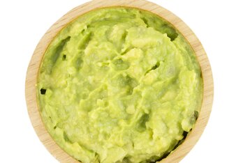 Foto von einem Holzschälchen mit grünem Avocado Dip. | © SONNENTOR