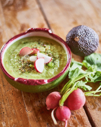 Auf dem Foto ist ein Teller mit Gurken-Avocado Suppe zu sehen. Daneben liegen Radieschen und eine Avocado. | © SONNENTOR