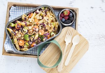 Auf dem Foto ist eine Form mit buntem Pasta-Gemüse-Salat zu sehen. Daneben steht auch ein Glas mit frischen Beeren. | © SONNENTOR