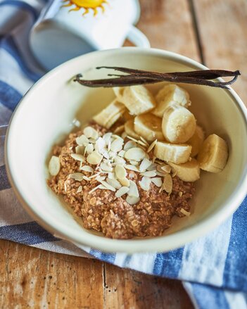 Auf dem Foto ist eine Schüssel mit Basenmüsli zu sehen. Garniert mit Bananen, und Mandelblättern. | © SONNENTOR