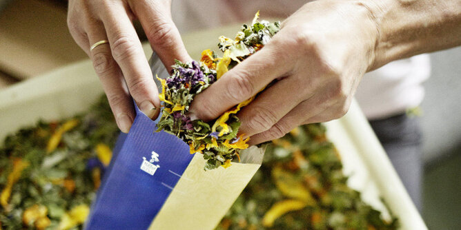 Sustainable packaging filled by hand at Sonnentor | © SONNENTOR