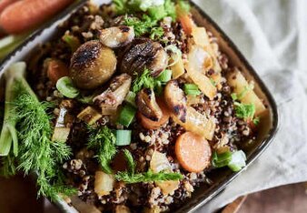 Auf dem Foto ist eine Schüssel mit Fenchel-Eintopf mit Quinoa zu sehen. Daneben liegen frische Kräuter und Karotten. | © SONNENTOR