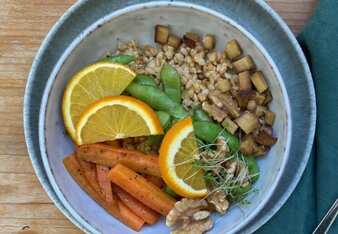 Auf dem Foto ist eine Schüssel mit Einkornreissalat, Edamame und Oregano auf einem Holztisch zu sehen. | © SONNENTOR