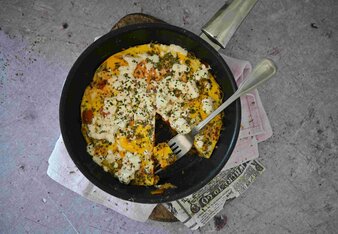 Auf dem Foto ist eine Pfanne mit Gemüsefrittata zu sehen. Von der Frittata fehlt bereits ein Stück. | © SONNENTOR