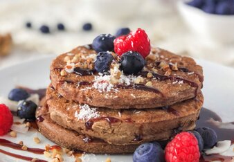 Auf dem Foto sind mehrere Buchweizen Pancakes übereinander zu sehen. Die Pancakes sind mit frischen Beeren und Nüssen garniert. | © SONNENTOR