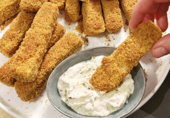 Auf dem Foto sind viele Tofu Sticks zu sehen. Man sieht wie jemand einen Tofu Stick in den Dip taucht. | © SONNENTOR