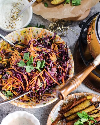 Auf dem Foto ist eine Schüssel gefüllt mit Kürbis und Rotkraut zu sehen. Daneben sind verschiedene Dips und Kartoffelsticks zu sehen. | © SONNENTOR