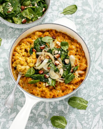 Auf dem Foto sieht man einen  Topf mit veganen Käsespätzle. Sie sind mit Babyspinat, Nüssen und Käse garniert. | © SONNENTOR