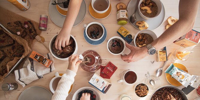 Auf dem Foto sieht man einen vollen Frühstückstisch mit mehren Knuspermüsli Schalen und weiteren Sonnentor Produkten. | © SONNENTOR