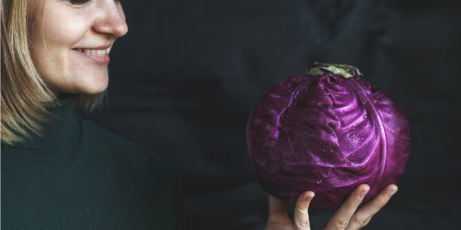 Auf dem Foto ist eine Frau zu sehen, die Rotkohl ansieht. | © SONNENTOR