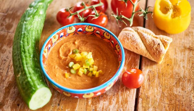 Auf dem Foto sieht man Gazpacho und frisches Gemüse. Auch ein Baguette ist zu sehen. | © SONNENTOR