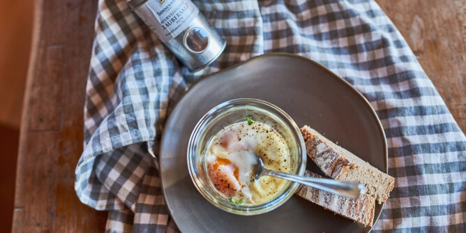 Auf dem Foto sieht man das Frühstück Ei im Glas. Daneben sind zwei Brotscheiben zu sehen. | © SONNENTOR