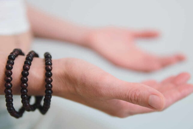 Auf dem Foto sieht man die Hände einer Frau mit den Handflächen nach oben gerichtet. Sie trägt drei Armbänder aus Holzkugeln. | © SONNENTOR